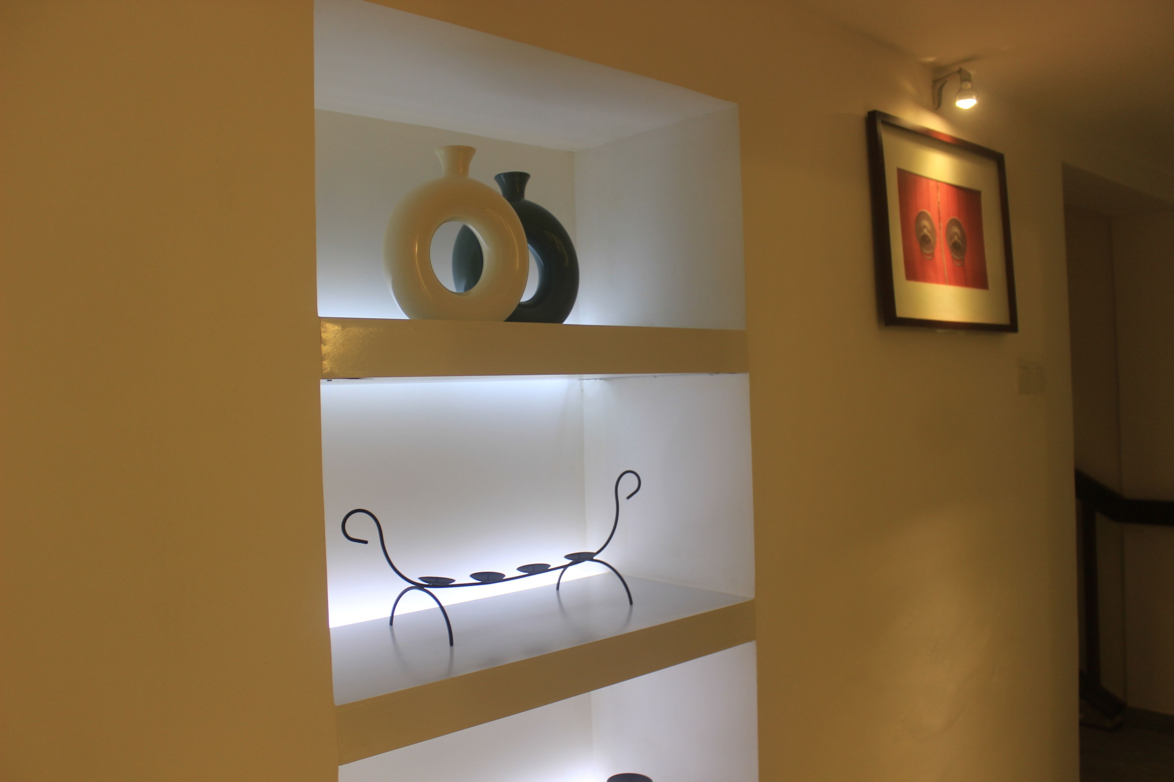 Une étagère ornée de vases décoratifs et un tableau encadré accroché au mur.