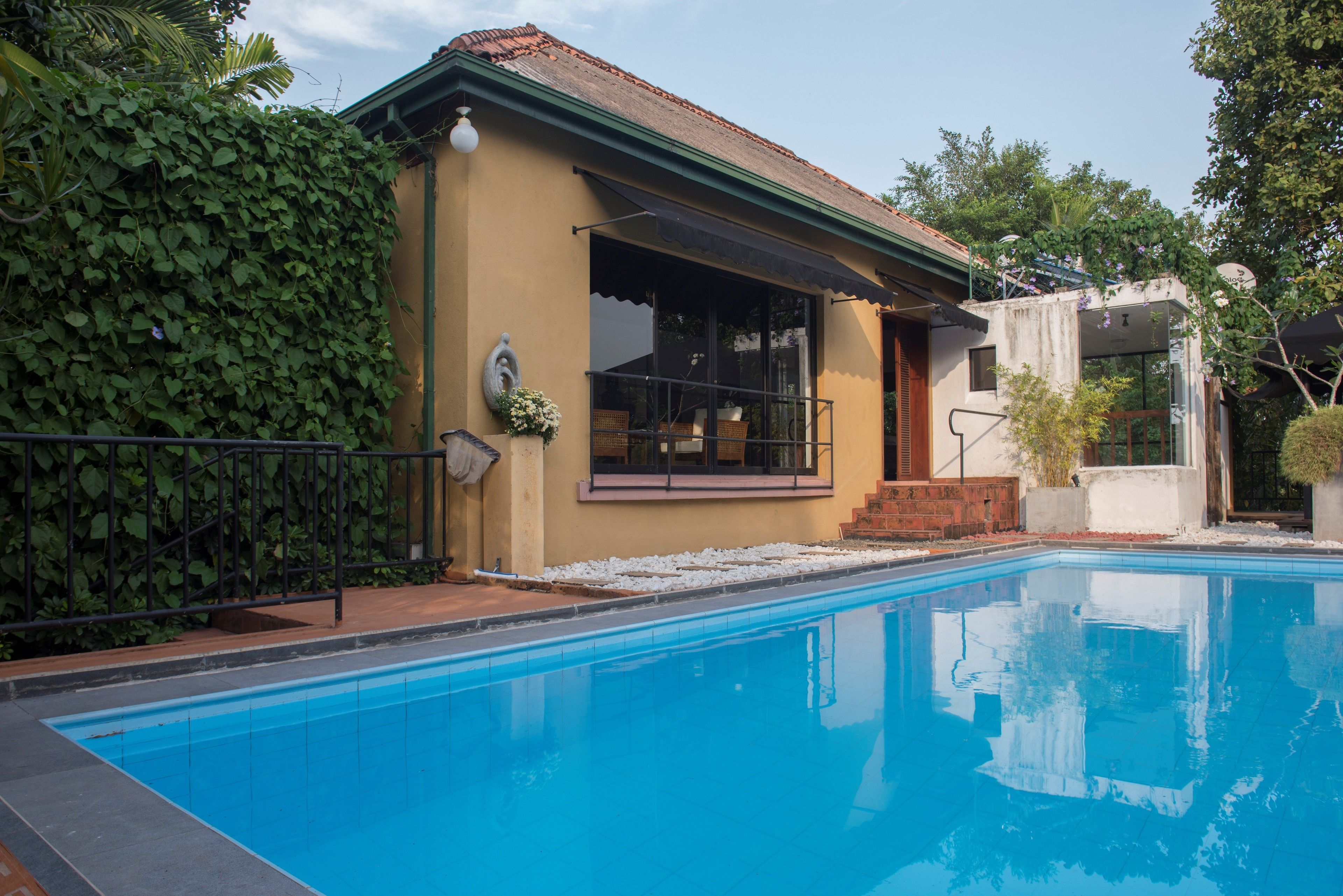 Une piscine avec une maison attenante.