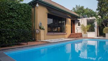 Une piscine avec une maison attenante.