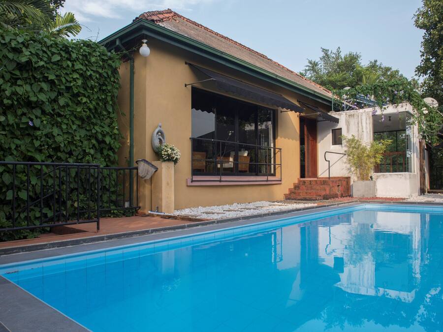 Une piscine avec une maison attenante.