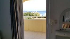 A room with a view of the sea, a balcony with a railing, and a small bedside table with a lamp. - Kontessa Apartments (Kos)