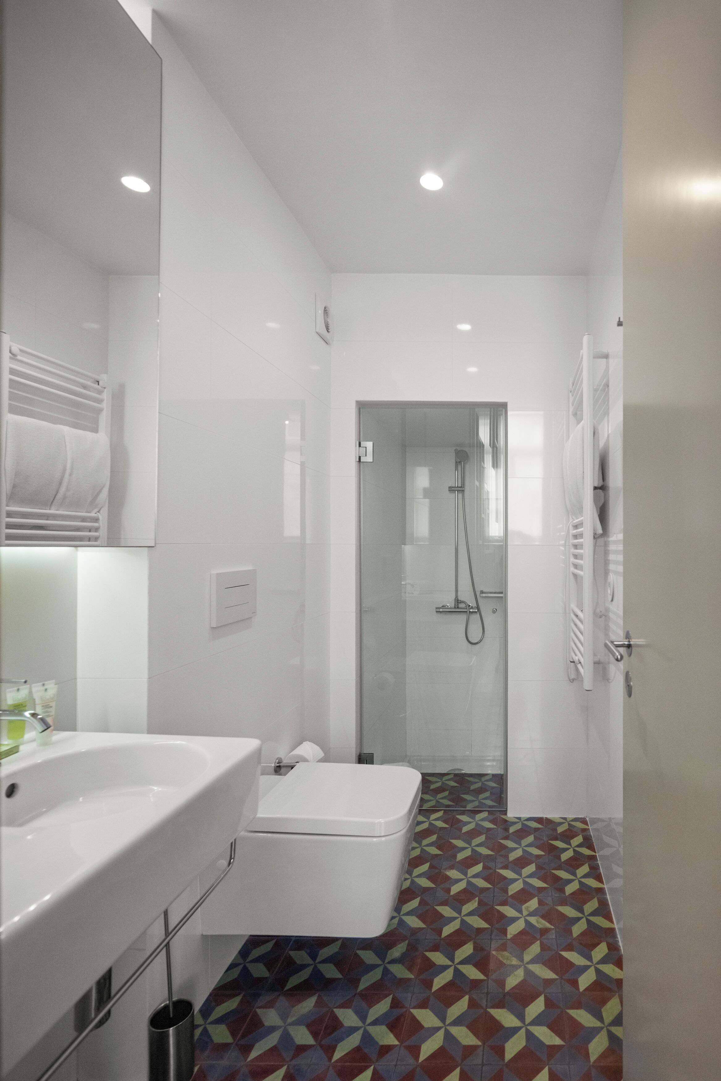 Casa de banho moderna com lavatório branco, sanita e área de duche.