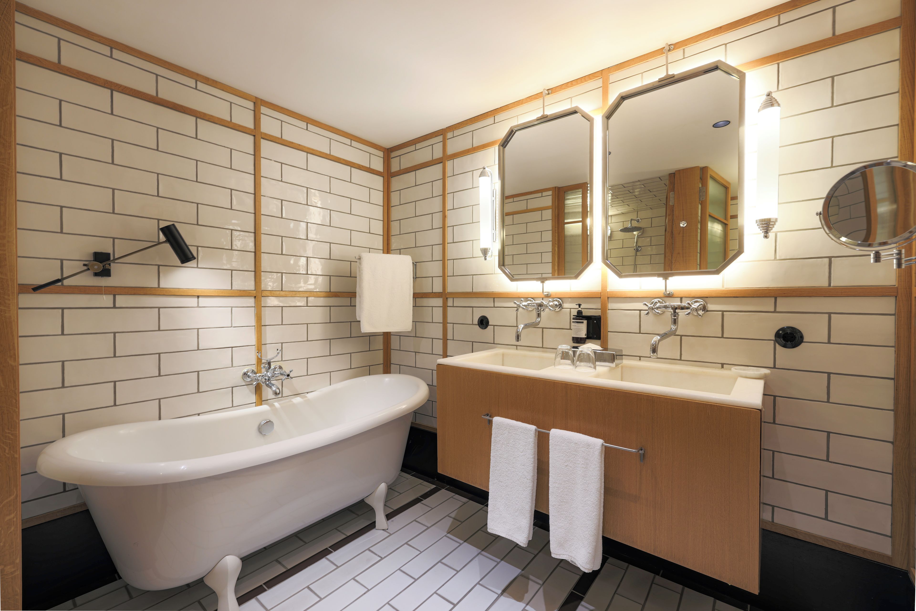 A modern bathroom with a freestanding bathtub, a vanity with a mirror, and a shower area.