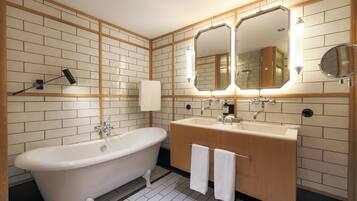 A modern bathroom with a freestanding bathtub, a vanity with a mirror, and a shower area.