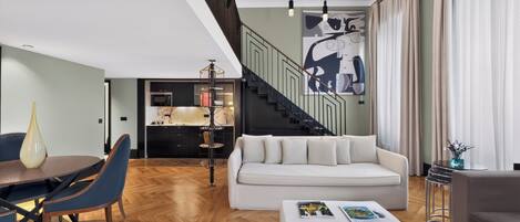 A modern living room with a sofa, coffee table, and dining area.