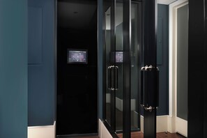 A modern elevator with a digital display, glass doors, and a metallic handle.