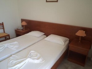 A double bed with white linens and two bedside tables with lamps. - Kamari Bay Hotel (Kos)