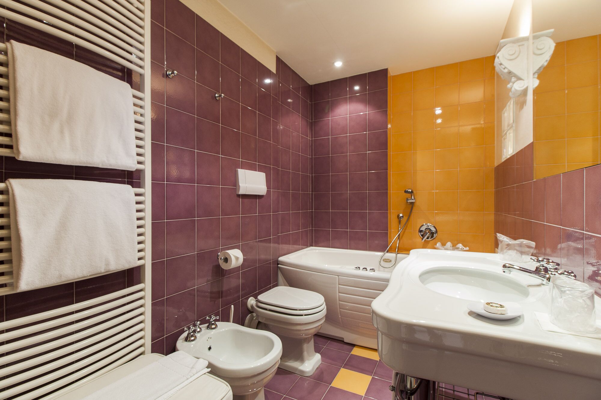 A bathroom with a bidet, toilet, and sink.