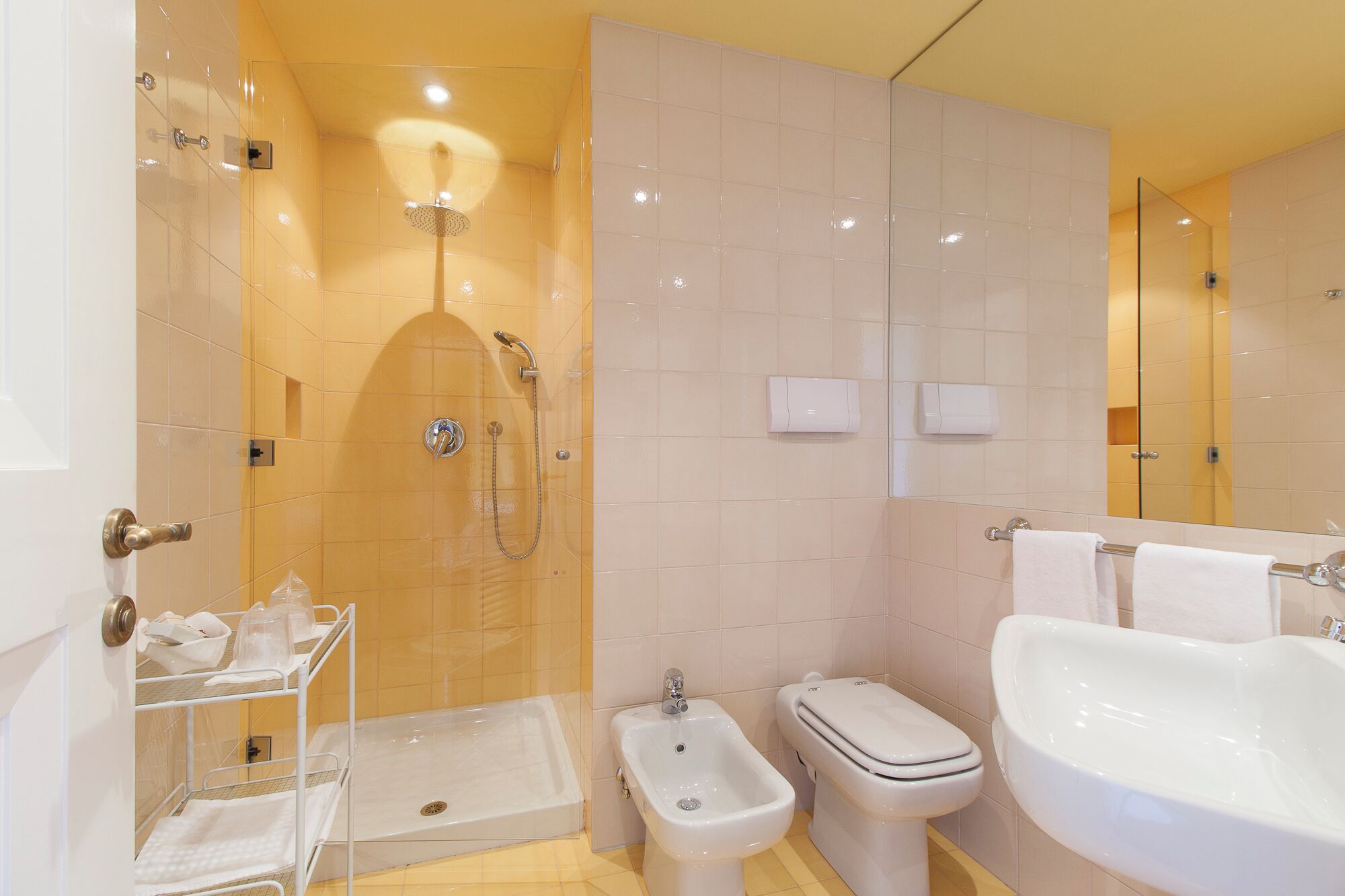Une salle de bain moderne équipée d’une douche, d’un bidet, de toilettes et d’un lavabo.
