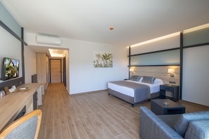 A modern hotel room with a bed, a desk, a sofa, and a TV. - Club Dizalya Hotel (Alanya)