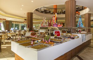 A buffet with various food items and a cake with a flag design. - Club Dizalya Hotel (Alanya)