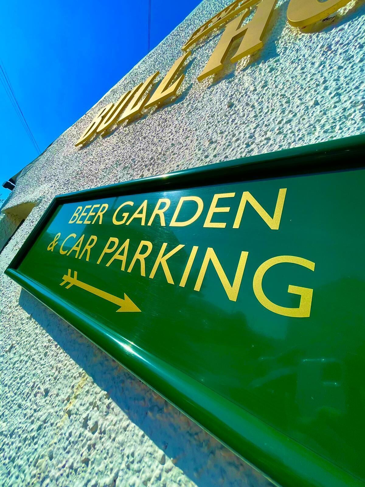 Señal que indica 'Beer Garden & Car Parking' con una flecha apuntando a la derecha.
