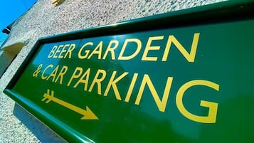 Señal que indica 'Beer Garden & Car Parking' con una flecha apuntando a la derecha.