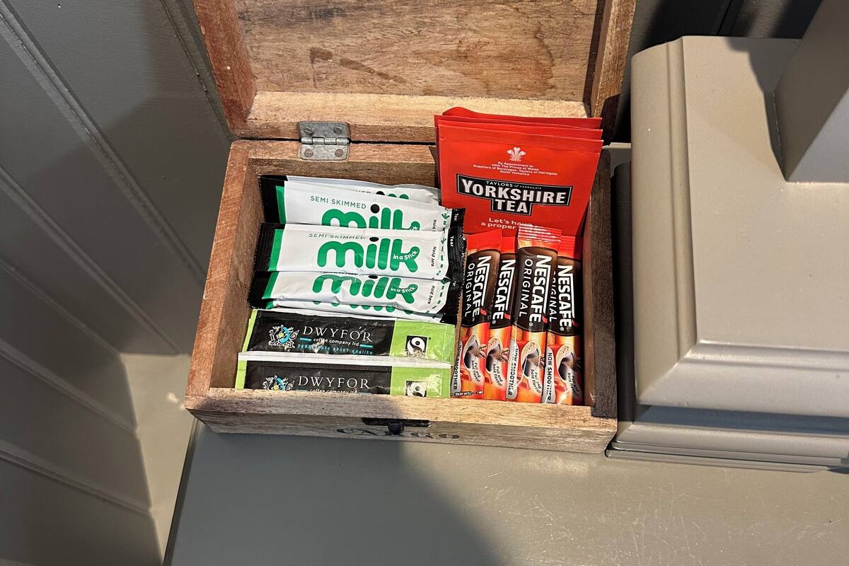 A wooden box containing various tea and coffee products.