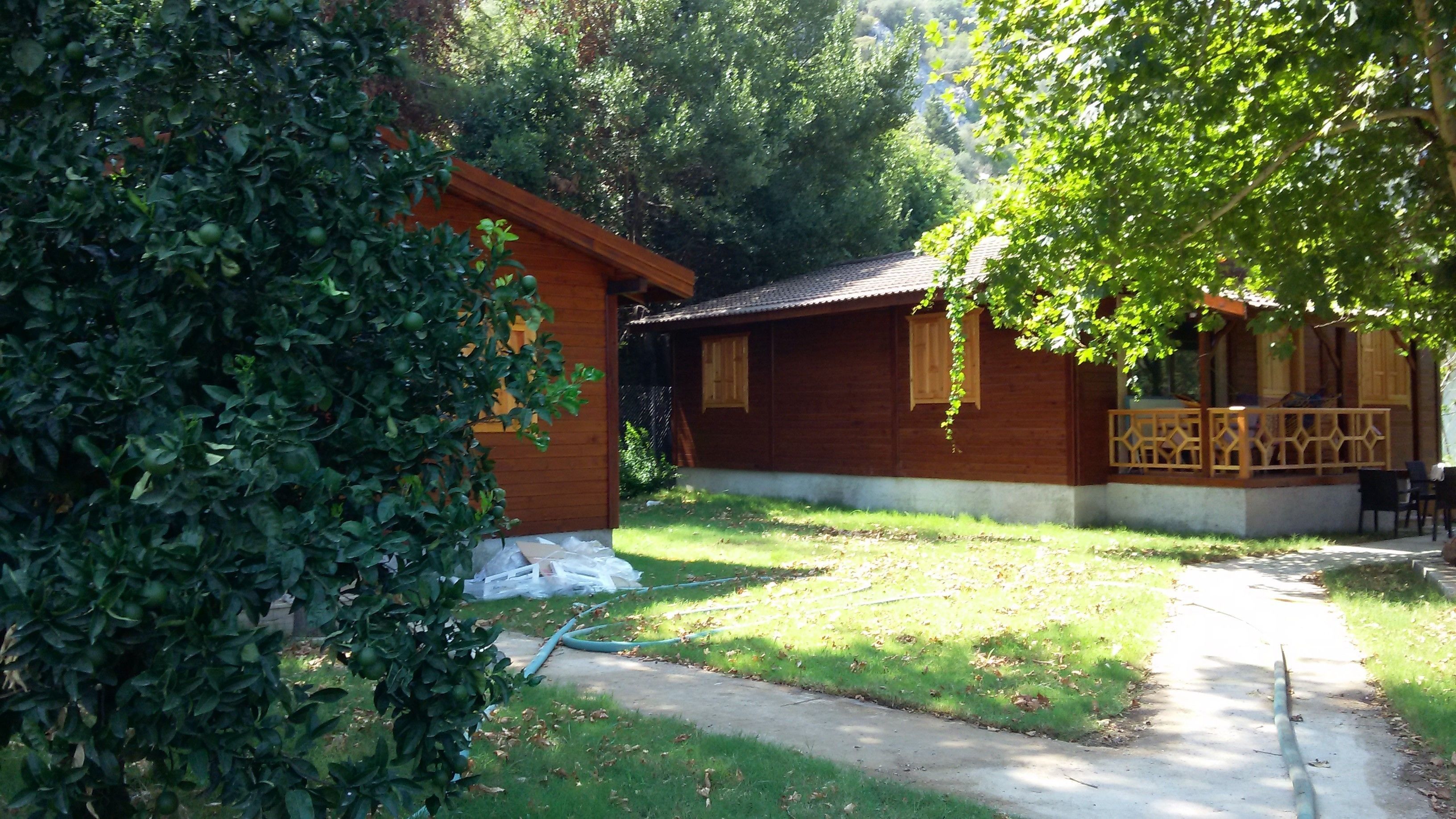 Una cabaña de madera con un porche y una pequeña mesa.