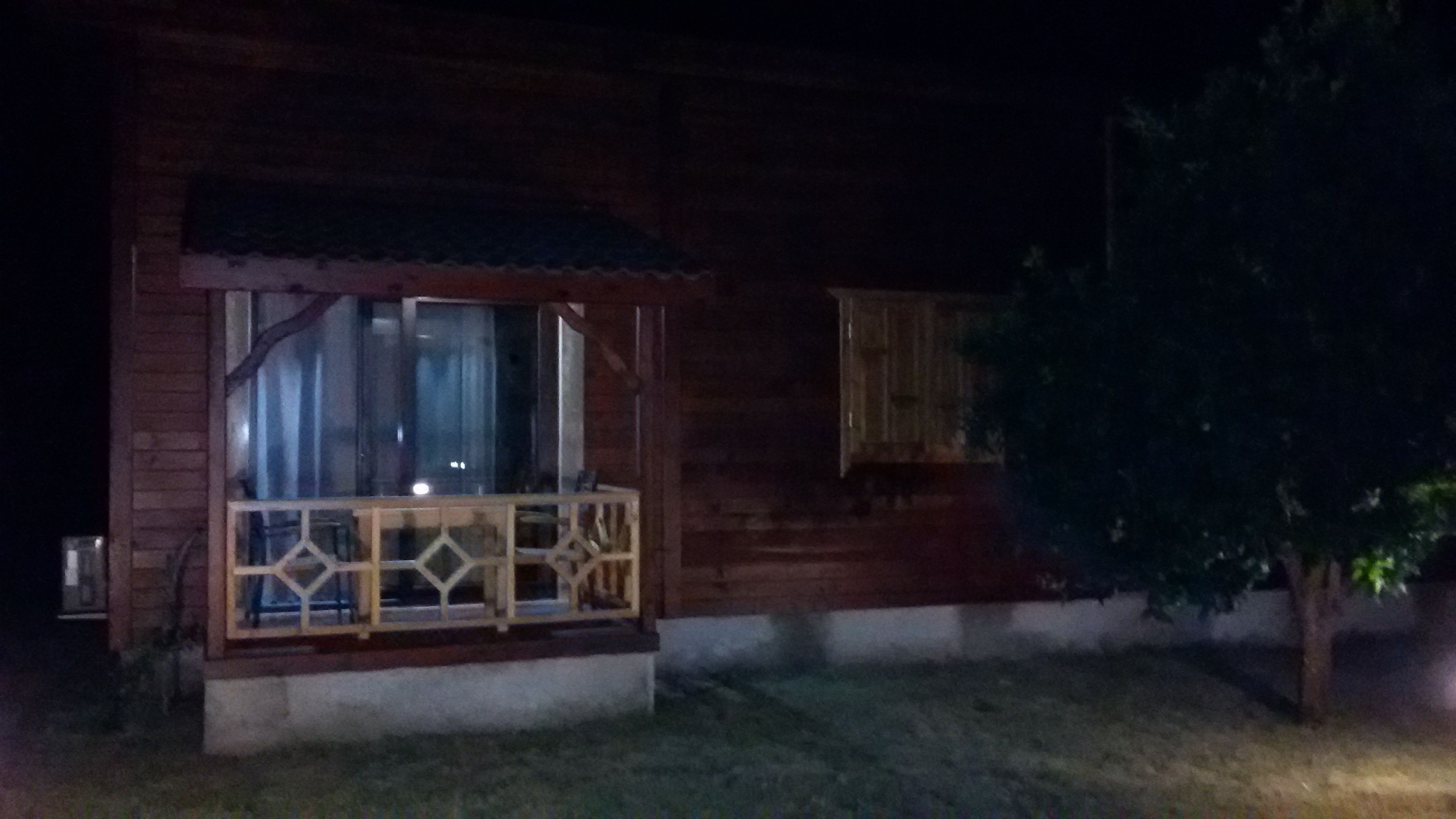 Una casa de madera con balcón, ventana y un pequeño porche.
