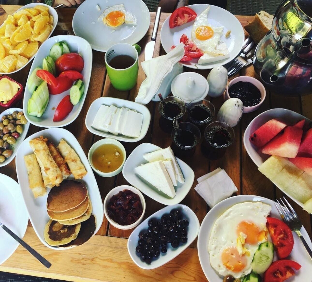 A table with various breakfast items including eggs, pancakes, and fruits.