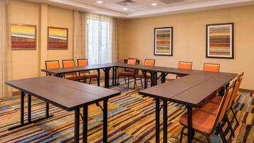 A conference room with a long table, multiple chairs, and colorful striped carpet.