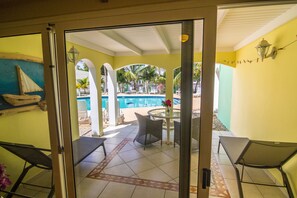 Deluxe Studio, Pool View, Poolside | Living area | 42-inch LED TV with cable channels, TV, books - Coral Paradise Resort (Kralendijk)