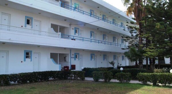 A multi-story hotel with balconies, a covered entrance, and a well-maintained garden. - Lagonas Beach Hotel (Rhodes)