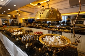 Ein reichhaltiges Buffet mit verschiedenen Speisen und einem dekorativen, goldenen Mittelstück.