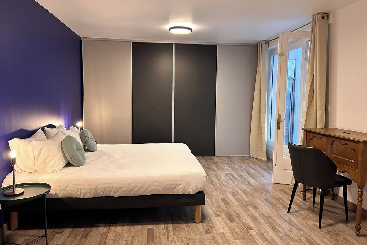 Une chambre à coucher comprenant un lit, une table de chevet et un bureau avec une chaise.