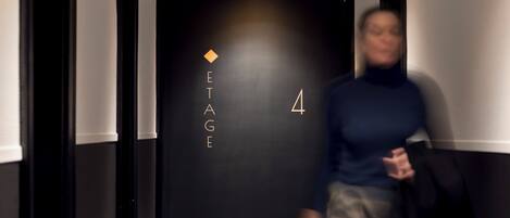 A hallway with a black wall featuring the text "ETAGE 4" and a small diamond symbol.