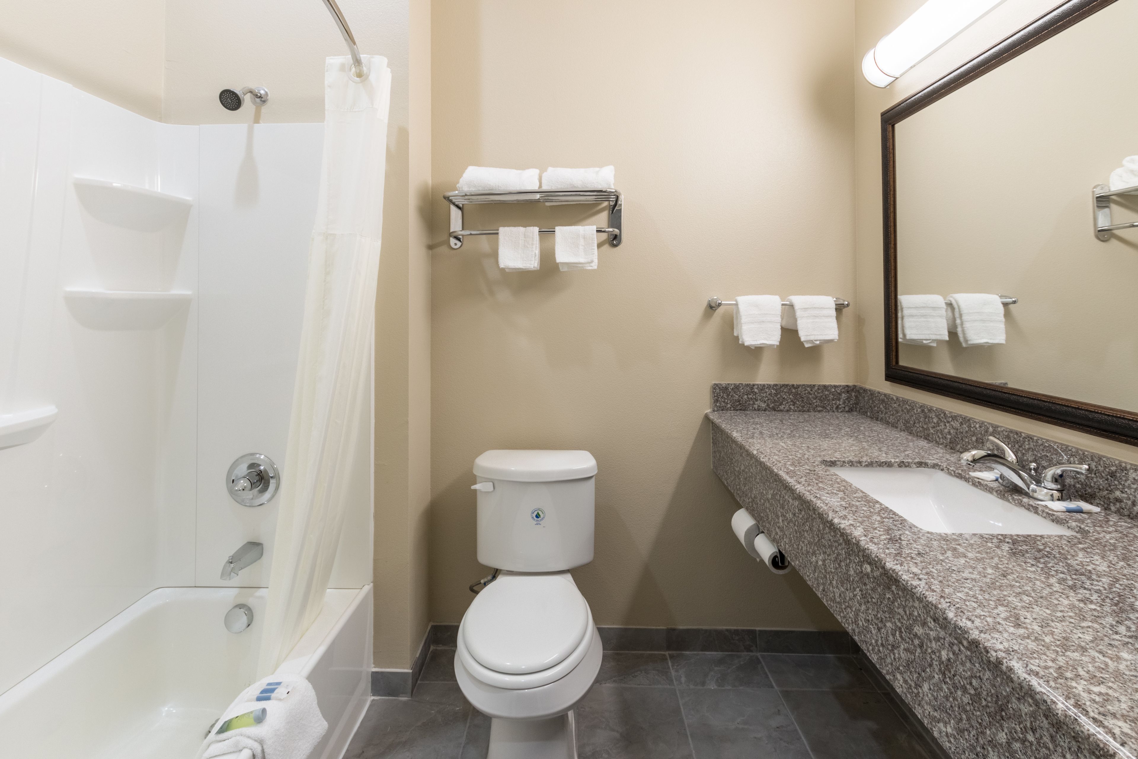 Un bagno con vasca, water, lavandino e porta asciugamani.