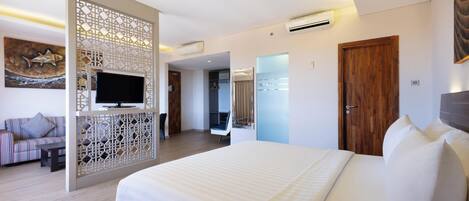 Quarto de hotel moderno com uma cama grande, televisão, porta de madeira e um painel decorativo.