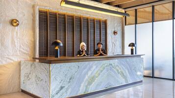 A reception desk with a marble top and a decorative panel with vertical slats.