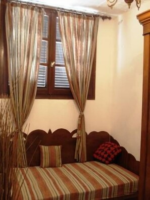 A room with a bed, a window with blinds, and a curtain. - Pension Lagoudera (Naxos)