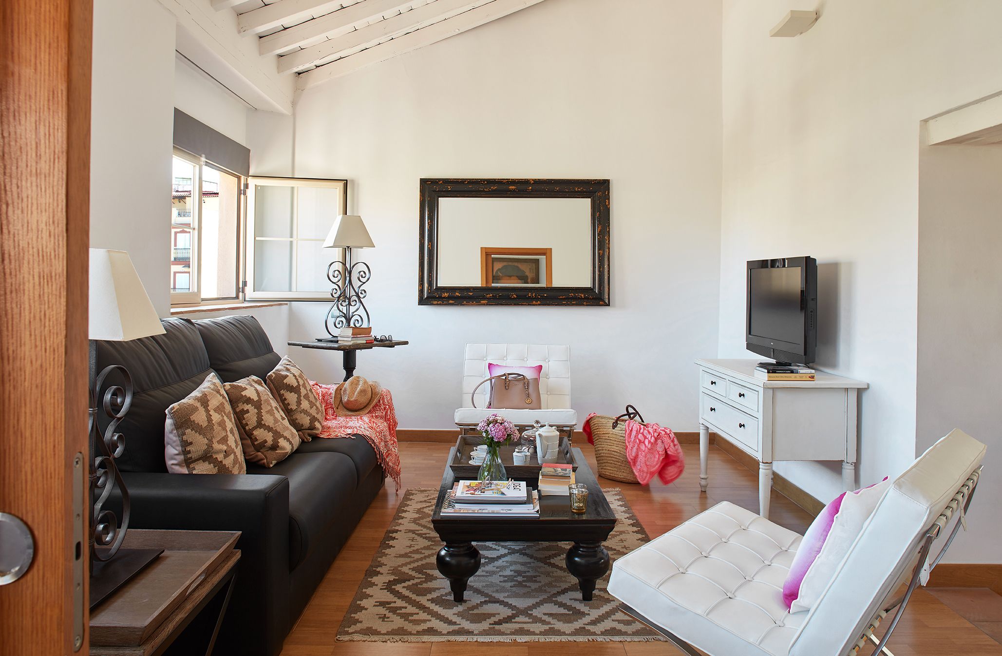 A living room with a sofa, coffee table, TV, and a chair.