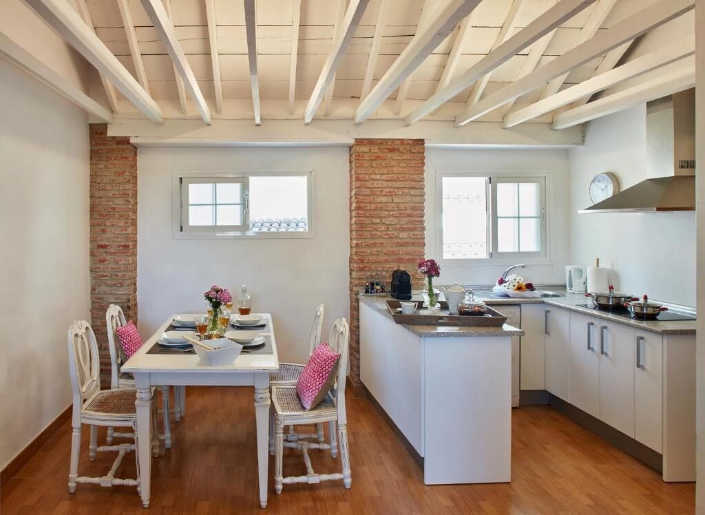 A kitchen with a central island, white cabinetry, and a brick accent wall.
