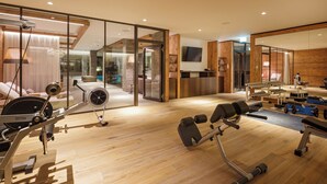 Un gimnasio moderno para el hogar con equipo de ejercicio, un espejo grande y vistas al salón.
