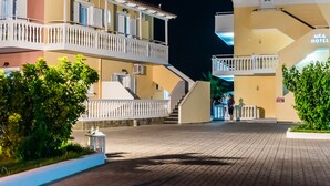 A hotel with a modern design, featuring balconies, a well-lit entrance, and a clear pathway leading to the main building. - Hera Zakynthos Hotel (Zakynthos)