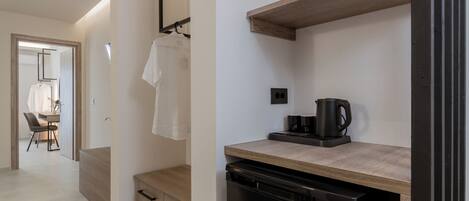 A modern kitchen with a dishwasher, a coffee maker, and a wooden countertop.