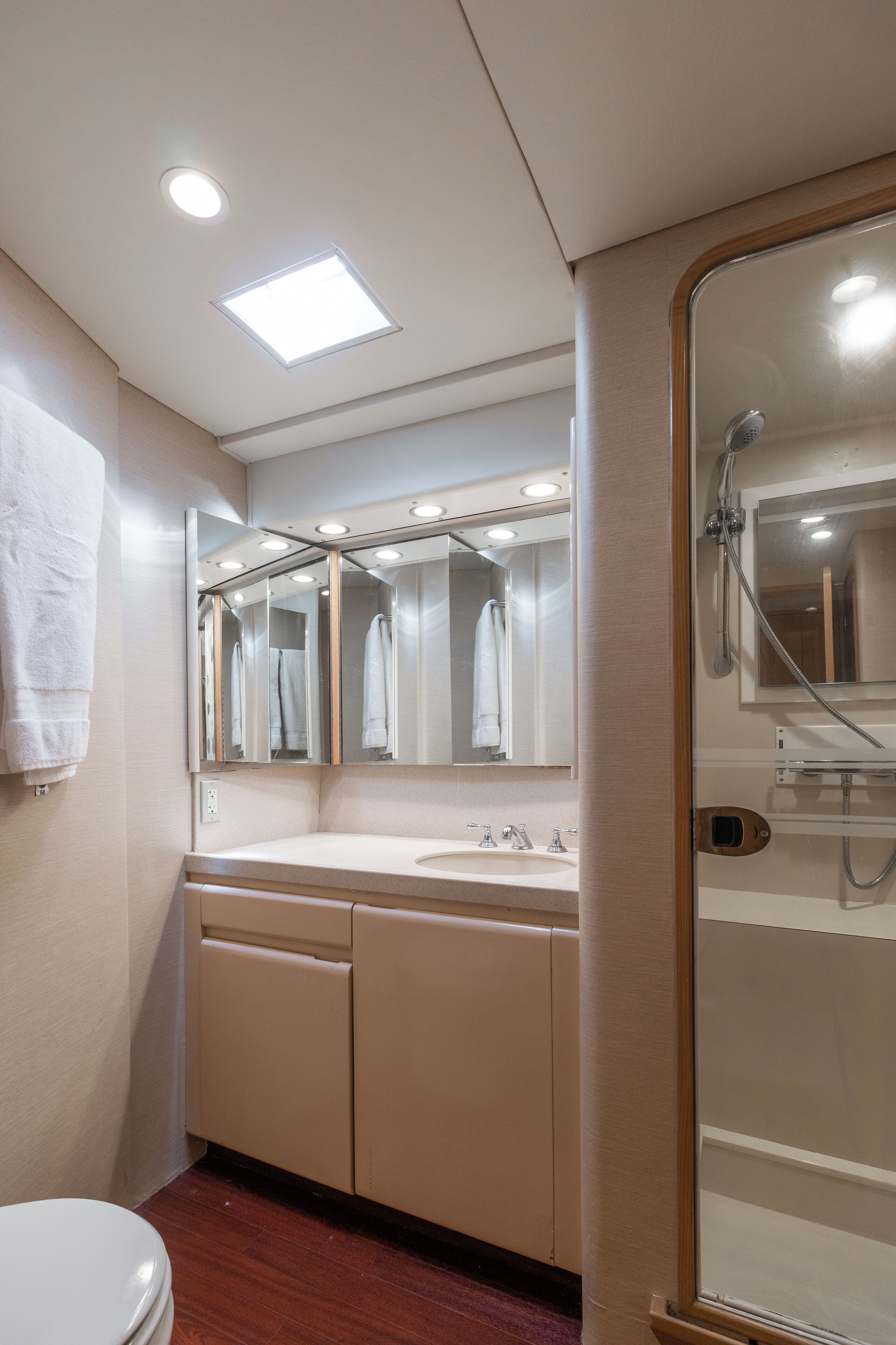 A bathroom with a white sink, mirror, and shower.