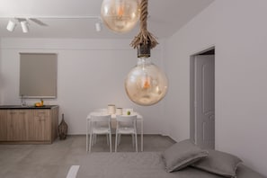 Un dormitorio moderno con cama, mesita de noche, espejo y lámpara colgante.