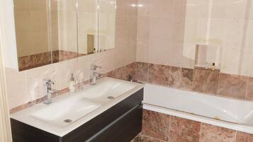 Comfort tweepersoonskamer, privébadkamer, aan tuin (Gustave Eiffel) | Badkamer | Een haardroger, handdoeken, zeep, shampoo