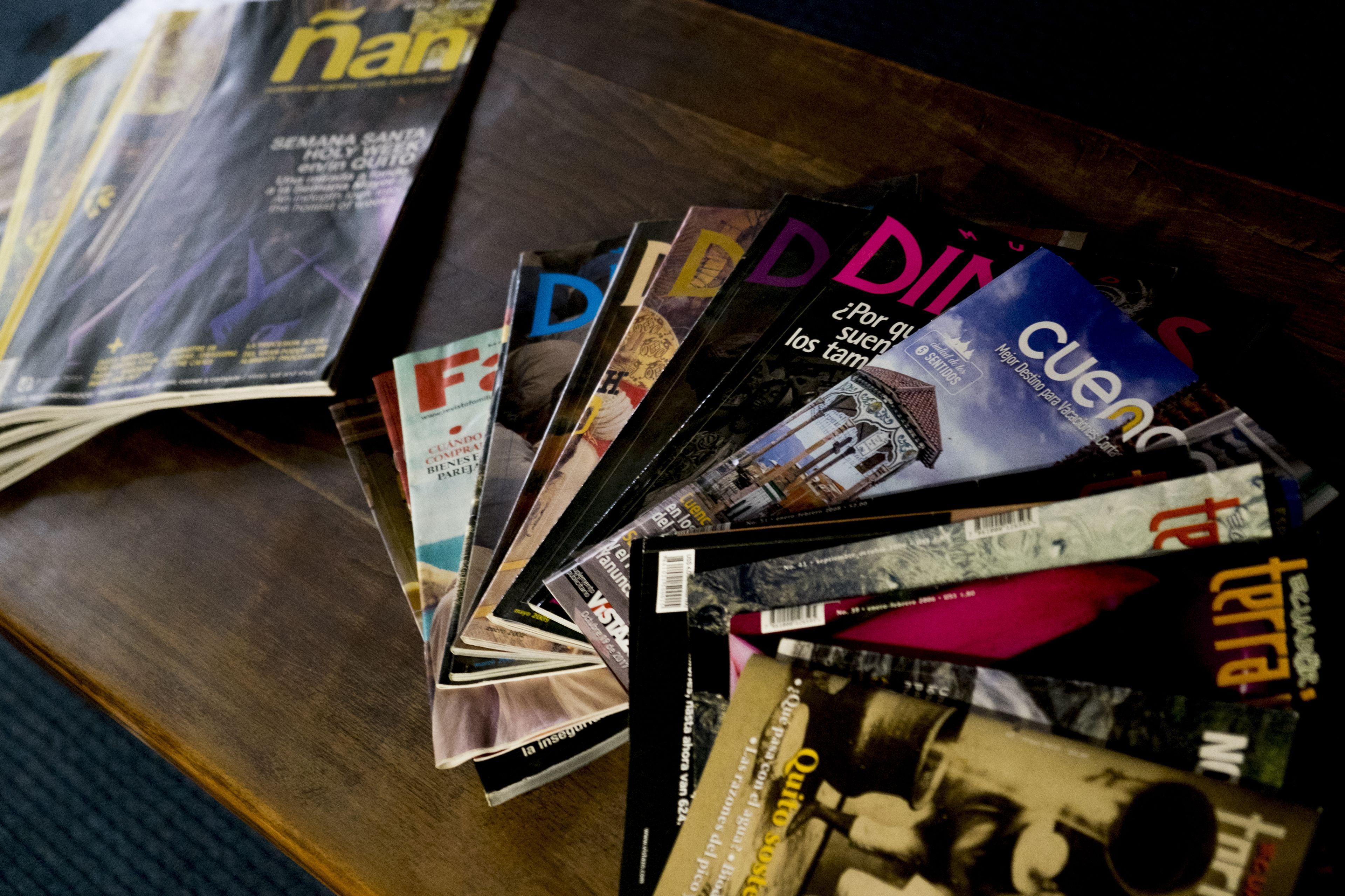 A collection of magazines on a wooden surface.