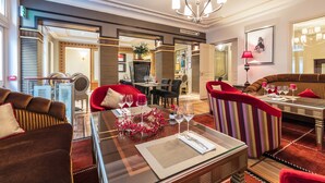 Een luxueuze hotellobby met een eetgedeelte, zitplaatsen en een kroonluchter.