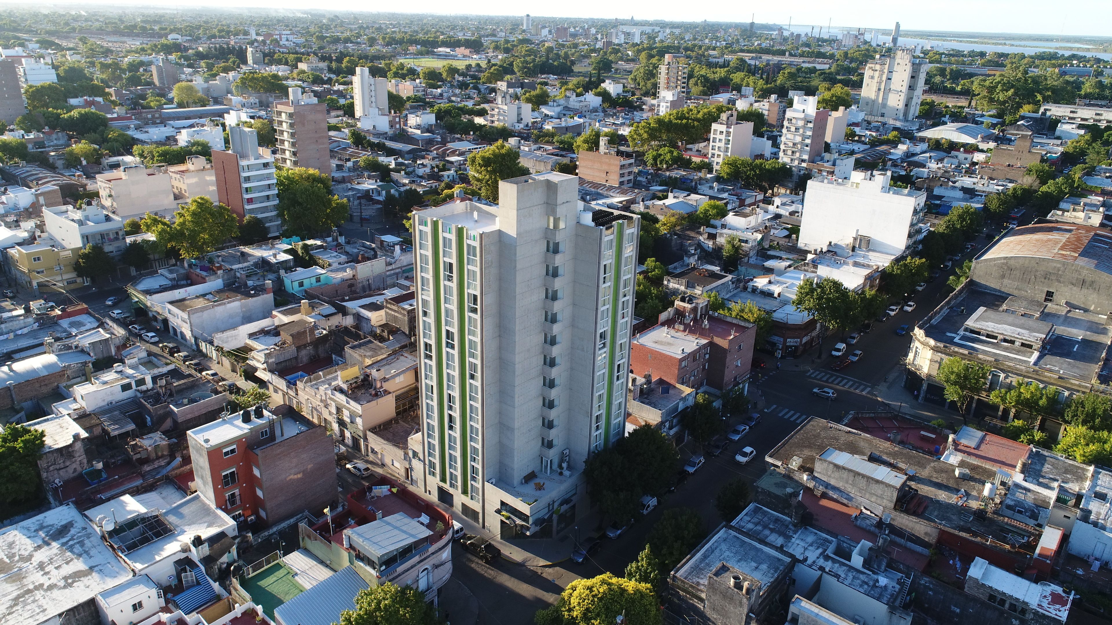 Vista aérea de uma área urbana densamente povoada, com diversos tipos de edifícios, incluindo prédios residenciais altos e estruturas menores.