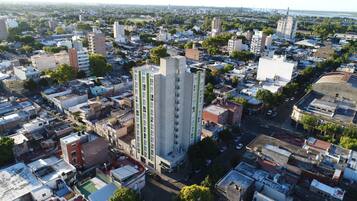 Vista aérea de uma área urbana densamente povoada, com diversos tipos de edifícios, incluindo prédios residenciais altos e estruturas menores.
