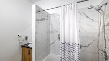 A modern bathroom with a shower, a toilet, and a sink.