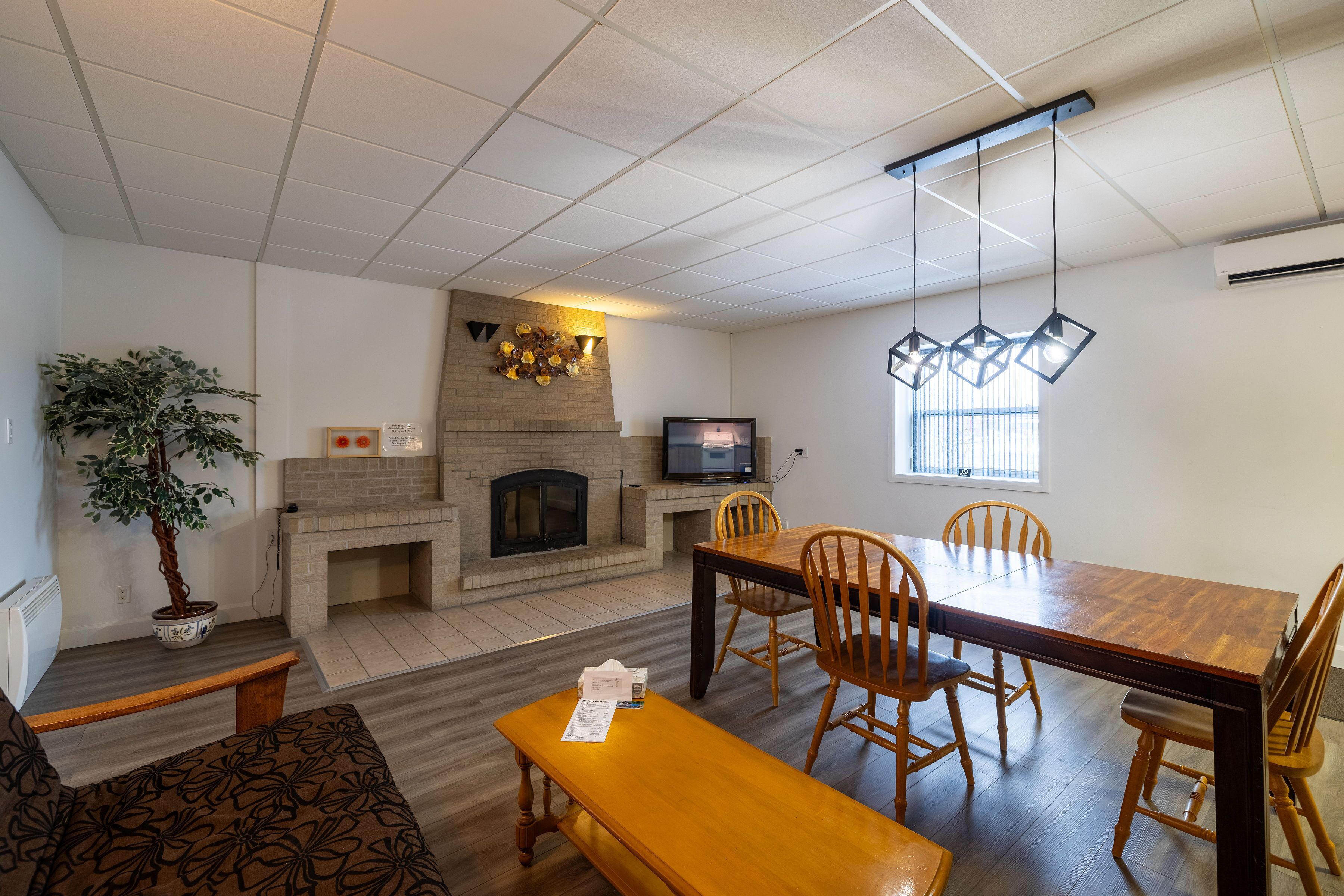 A modern living room with a fireplace, dining table, and comfortable seating.