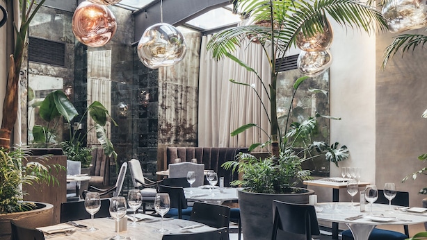 Un interior de restaurante moderno con suelo a cuadros, varias mesas para comer y sillas.