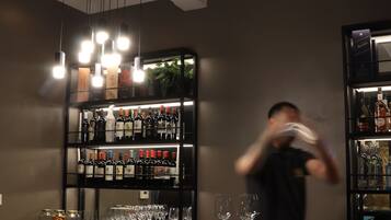 A bar area with a round table, chairs, and shelves of bottles.