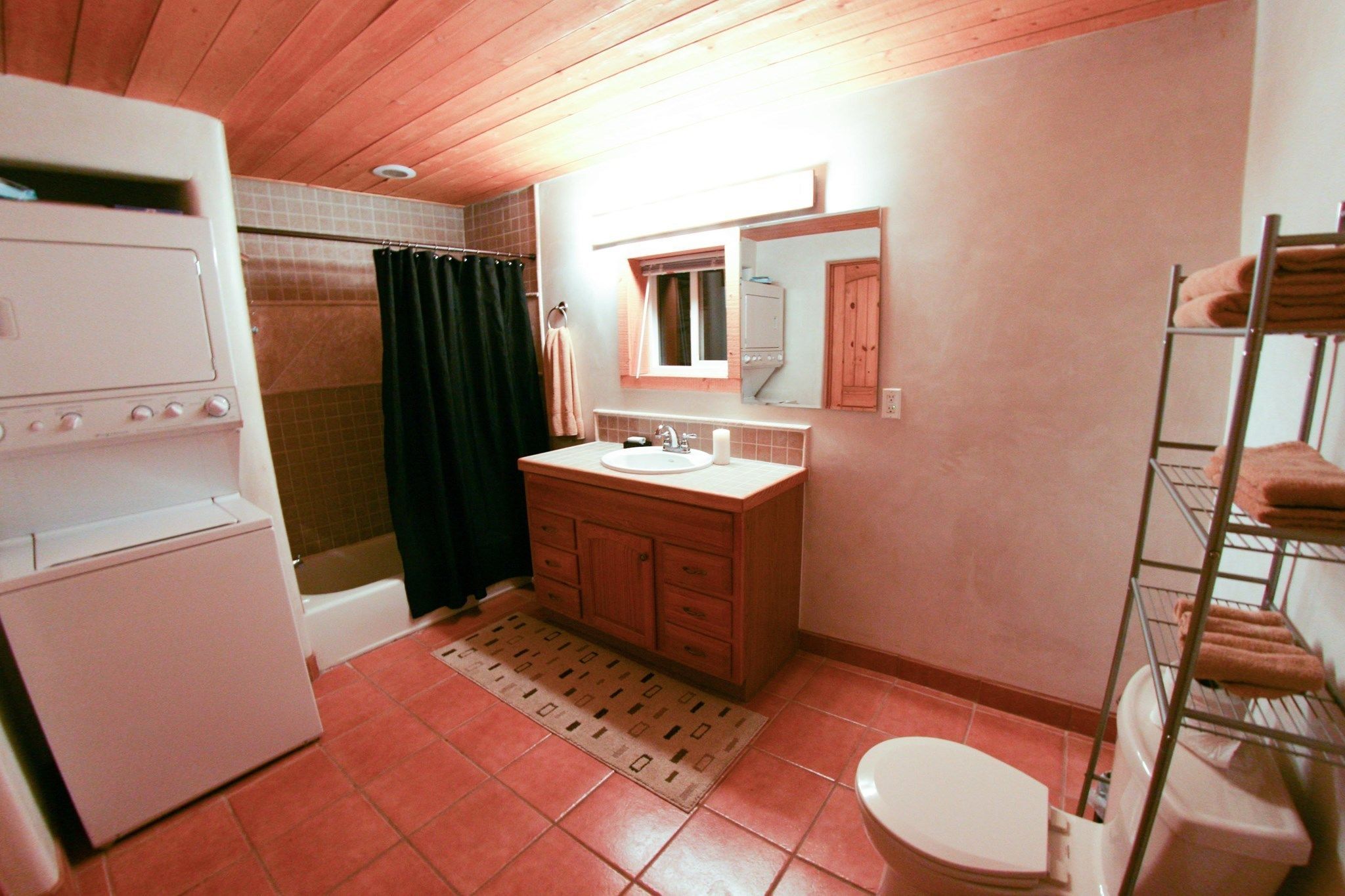 A compact bathroom with a sink, mirror, and toilet.