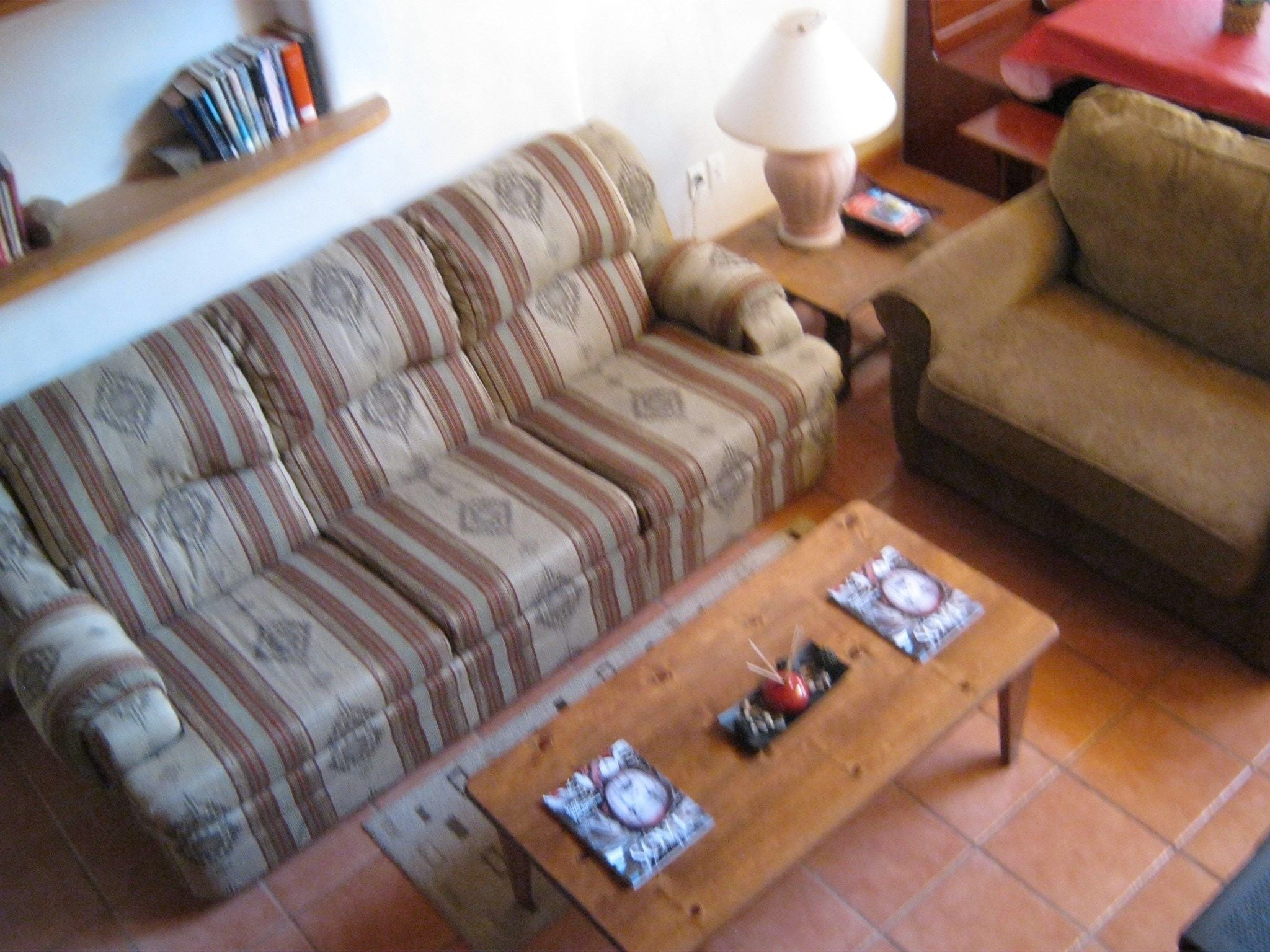 A living room with a striped sofa, a wooden coffee table, and a lamp.