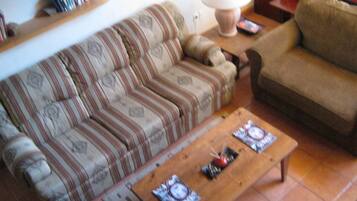A living room with a striped sofa, a wooden coffee table, and a lamp.